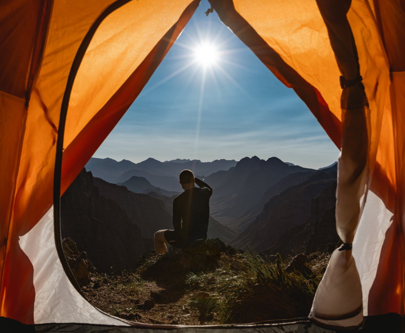 First Ascent Explore Page 1 person looking at the mountain views with his First Ascent hiking tent