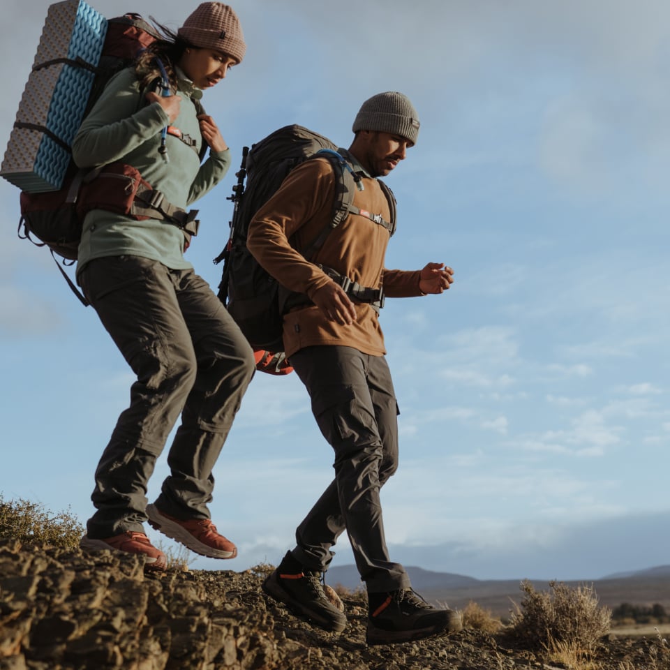 Two ladies walking in the forest with First Ascent hiking apparel and gear