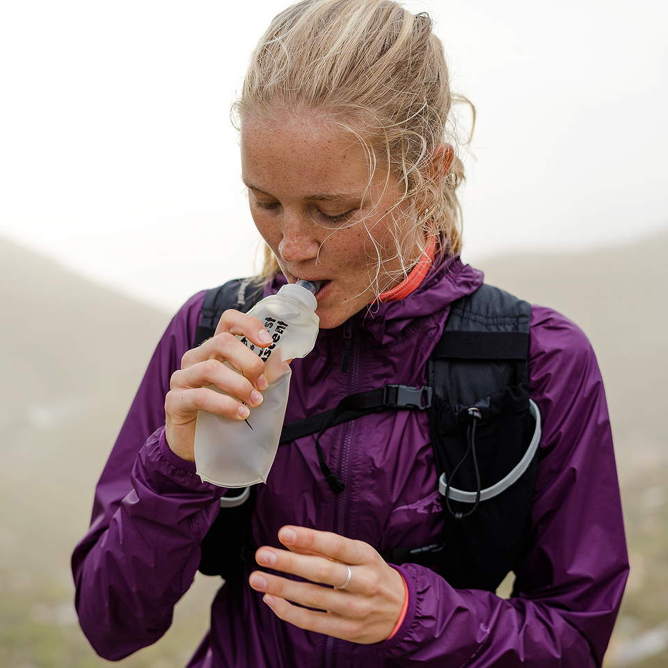 Girl drinking water from a First Ascent soft bottle